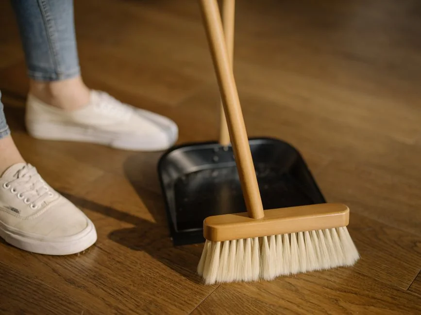 home-img Un homme nettoie une porte vitrée à l’intérieur en utilisant un vaporisateur et un chiffon.